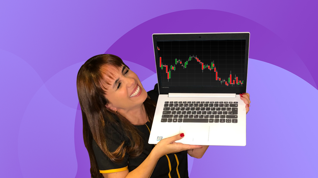 Alice Porto segurando um computador com operações day trade.